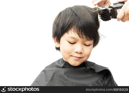 A boy is cut his hair by hair dresser isolated over white background