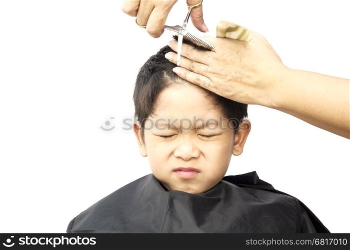 A boy is feeling itchy while cutting his hair by hair dresser isolated over white background