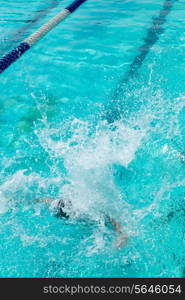 A boy jumps into the pool.