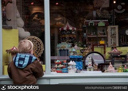 A boy looking in a shop window