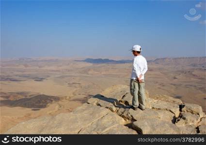 A boy near the cliff of the crater Makhtesh Ramon