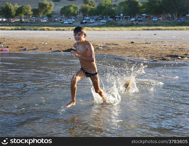 A boy plays in the warm water of lake Kinneret