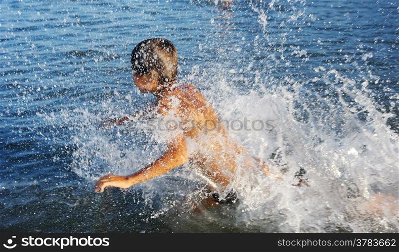 A boy plays in the warm water of lake Kinneret
