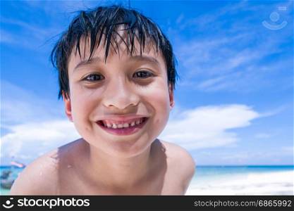 a boy smiling at the beach