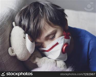 A boy tired from chest coughing wearing face mask for protect pm2.5,Child falling sleep while playing with toy, Kid stay at home for protection coronavirus,flu outbreak and illness protection concept
