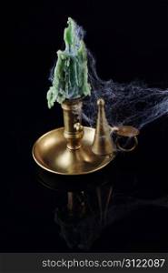 A brass candlestick covered with a cobweb, on black. Ideal for Halloween.
