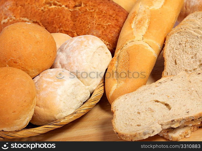 A breadboard and basket full of bread.