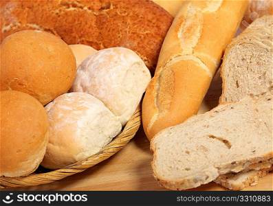 A breadboard and basket full of bread.