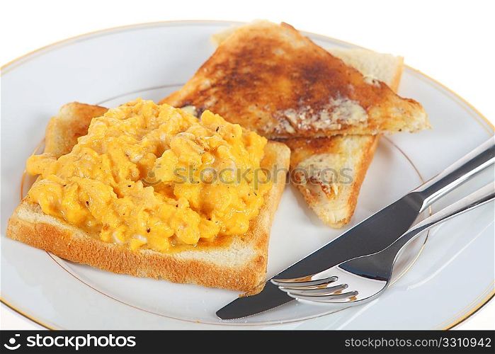A breakfast of scrambled egg on toast, isolated on a white background.
