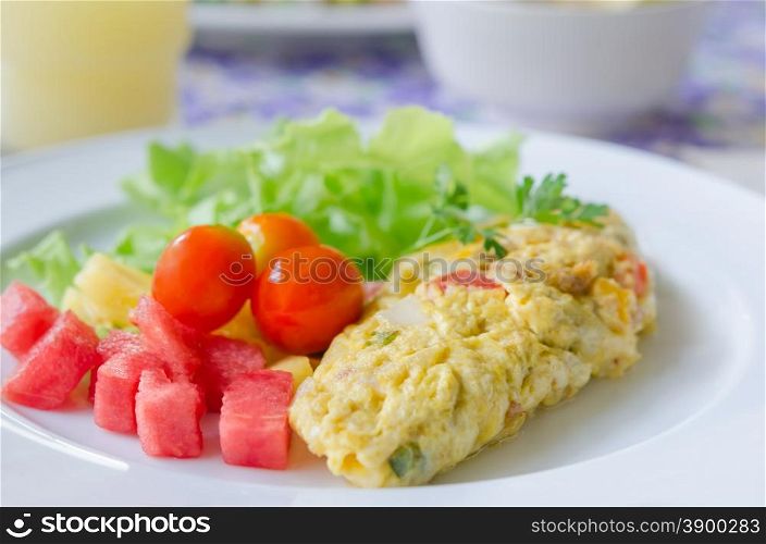 A breakfast , omlette with mix fruit salad