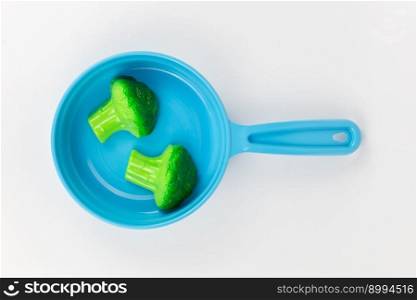 a breakfast with broccoli in a pan on a white background, children&rsquo;s plastic toy. breakfast with broccoli in a pan on a white background, children&rsquo;s plastic toy