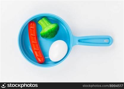 a breakfast with broccoli in a pan on a white background, children&rsquo;s plastic toy. breakfast with broccoli in a pan on a white background, children&rsquo;s plastic toy