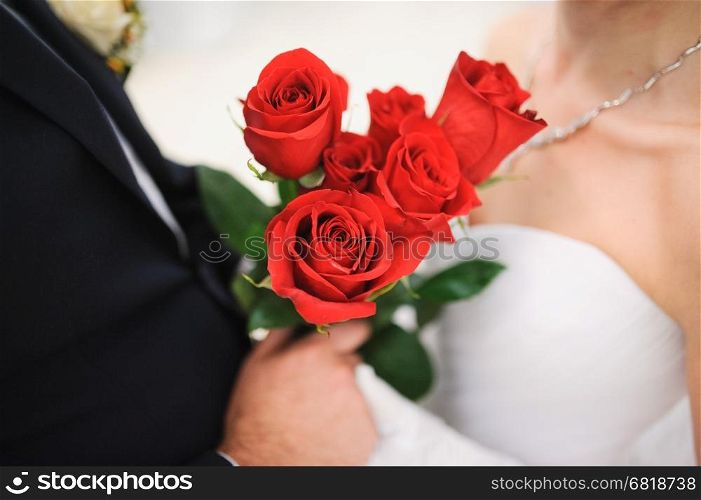 A bride and groom with flowers roses on wedding day
