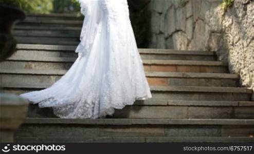 a bride in a wedding dress stands on the stairs