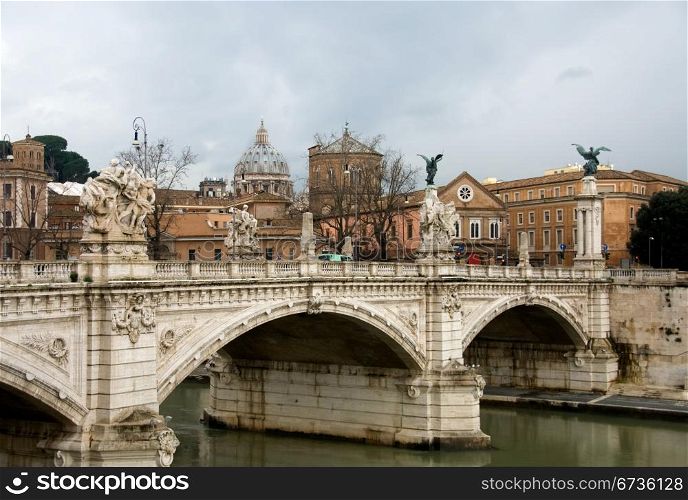 A bridge over the Tiber River, Rome, Italy, with the imposing dome of St Peter&rsquo;s Bascilica in the background