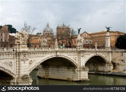 A bridge over the Tiber River, Rome, Italy, with the imposing dome of St Peter&rsquo;s Bascilica in the background