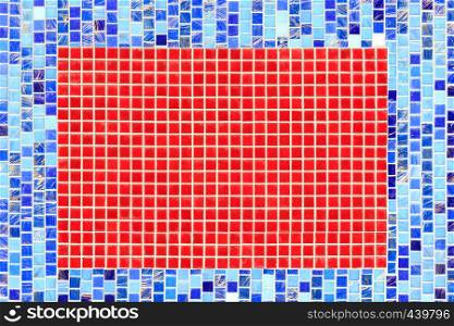 A bright abstraction of a mosaic wall of ceramic blue mosaic in the middle of a rectangle of red mosaic.. On the wall lined with blue ceramic mosaic the selected fragment is lined with red mosaic.