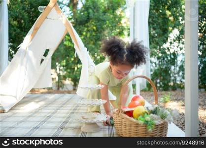 A bright and cute little girl with fun playing in the garden of the house.