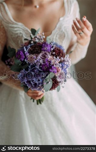A bright purple bouquet in womens hands.. A lilac - purple bouquet in womens hands 3857.