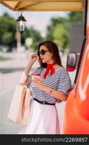 A bright Russian beauty on a summer shopping trip.. A happy girl walks around the city and shops on a bright day 4204.
