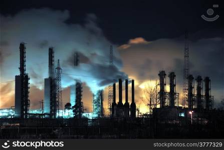 A brightly lit industrial site at night with plumes of smoke coming from chimneys. &#xA;Russia, Western Siberia.