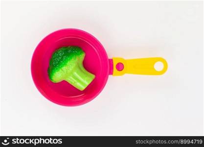 a broccoli cabbage in a pan with a spoon and fork on a white background. broccoli cabbage in a pan with a spoon and fork on a white background