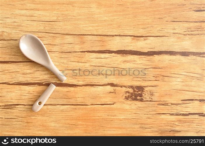 A broken beige glass teaspoon