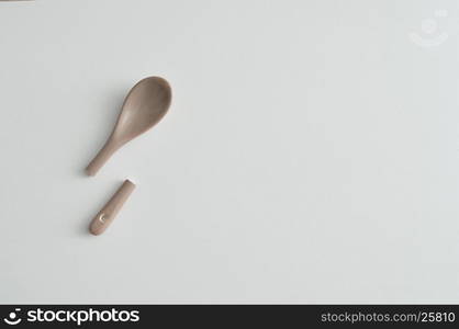 A broken beige glass teaspoon