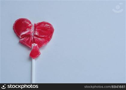 A broken red heart lollipop symbolizing a broken heart