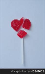 A broken red heart lollipop symbolizing a broken heart