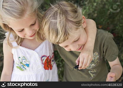 A brother and sister with a beetle
