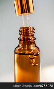 A brown cosmetic bottle with bubbles in the spotlight. Perfectly demonstrates the technological efficiency and effectiveness of cosmetics.. Pipette with cosmetic oil in a brown bottle with bubbles