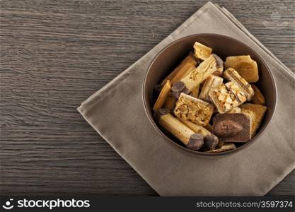 A brown cup full of biscuits over a wooden table