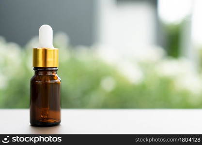 A brown glass bottle with dropper on the table. Concept of aroma oil, cosmetic, and beauty skin.