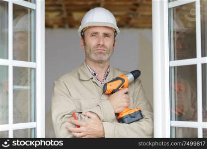 a builder handyman posing with drill
