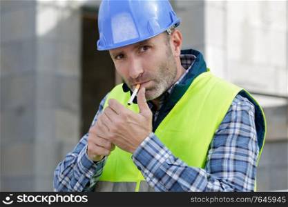 a builder lighting a cigarette