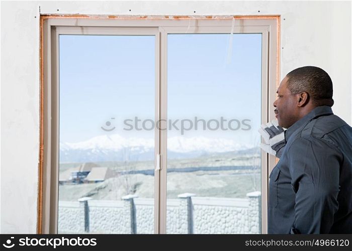 A builder looking out of a patio door