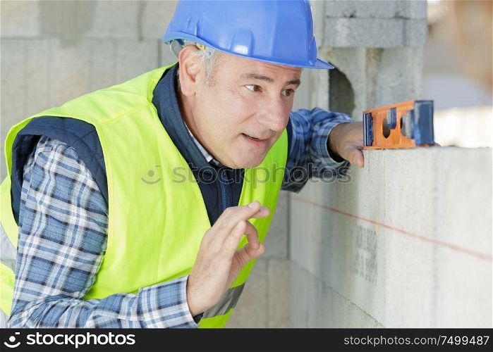 a builder measuring a wall