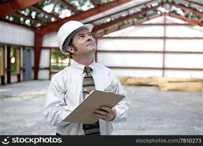 A building inspector examining the the steel girders in a building under construction. Horizontal view.