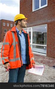 A building inspector visiting a construction site with a checklist in his hand