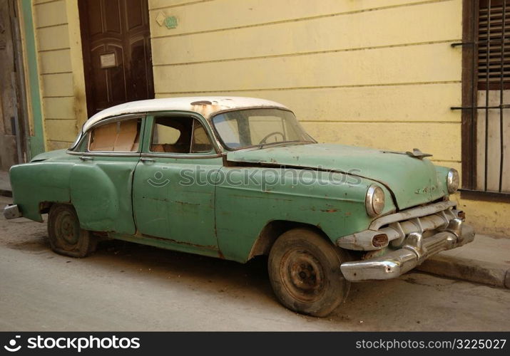 A building structure with an antique car parked in front, Havana, Cuba