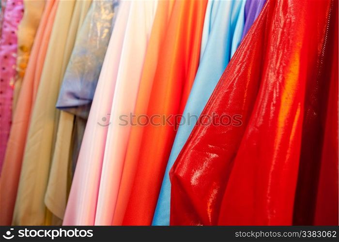 A bulk collection of silk cloth hanging on rolls
