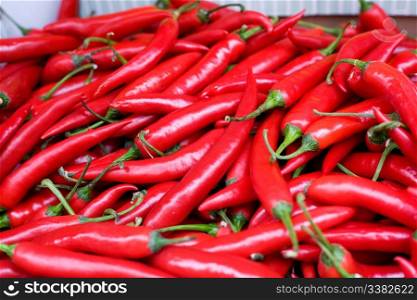 A bulk display of hot red peppers