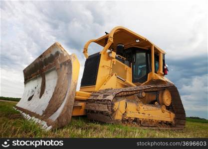 A bulldozer sitting idle on a construction site, shot at an angle.