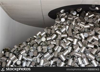 A Bunch of Aluminum Can Coming Out from Dark Hole from Ceiling in White Room