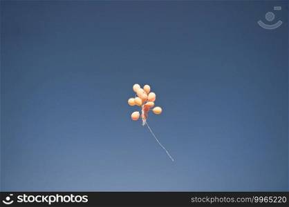 A bunch of balloons flying high in the sky.. Bouquet of balloons in the blue sky 2334.