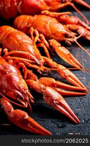 A bunch of boiled crayfish on the table. Against a dark background. High quality photo. A bunch of boiled crayfish on the table.