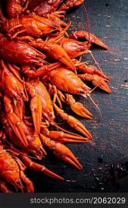 A bunch of boiled crayfish on the table. Against a dark background. High quality photo. A bunch of boiled crayfish on the table.