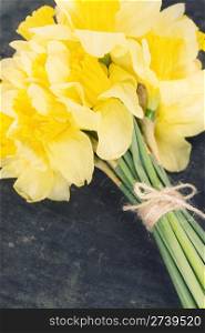 a bunch of daffodils on the wooden board