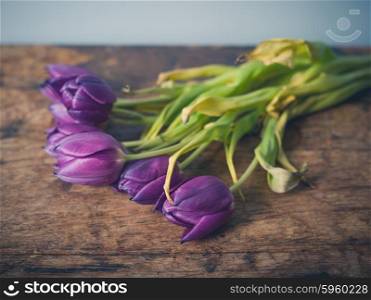 A bunch of dead flowers on a wooden table